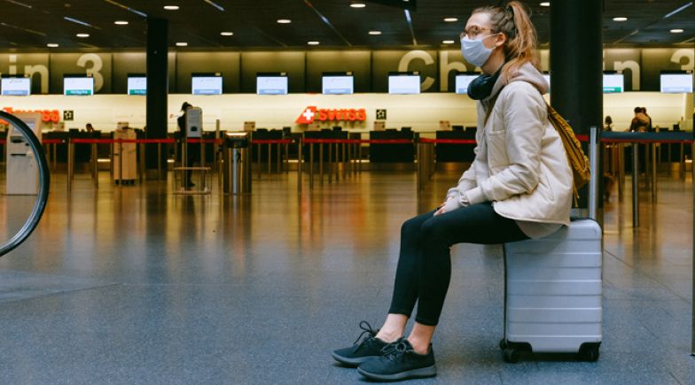 Young woman in face mask at airport